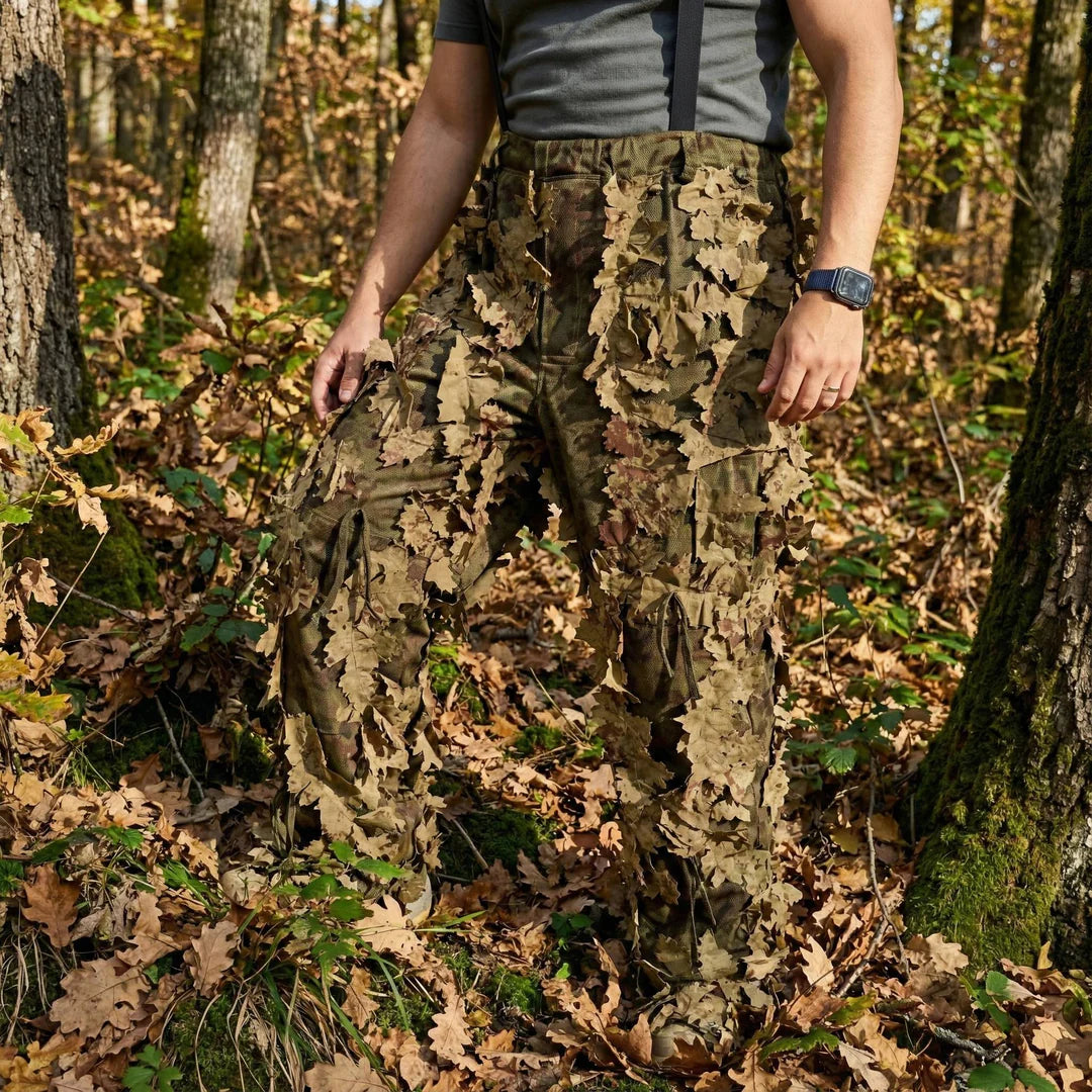KMCS Ghillie Suit Oakland, featuring green and brown camouflage elements with a leaf-style texture for outdoor concealment.