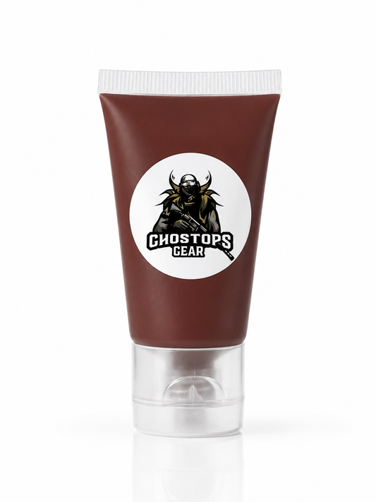 A squeeze tube of Ghosts Gear product in a dark reddish-brown color, featuring a white circular logo with a black horned soldier graphic. The tube has a clear plastic cap and is shown on a clean white background with a soft reflection.